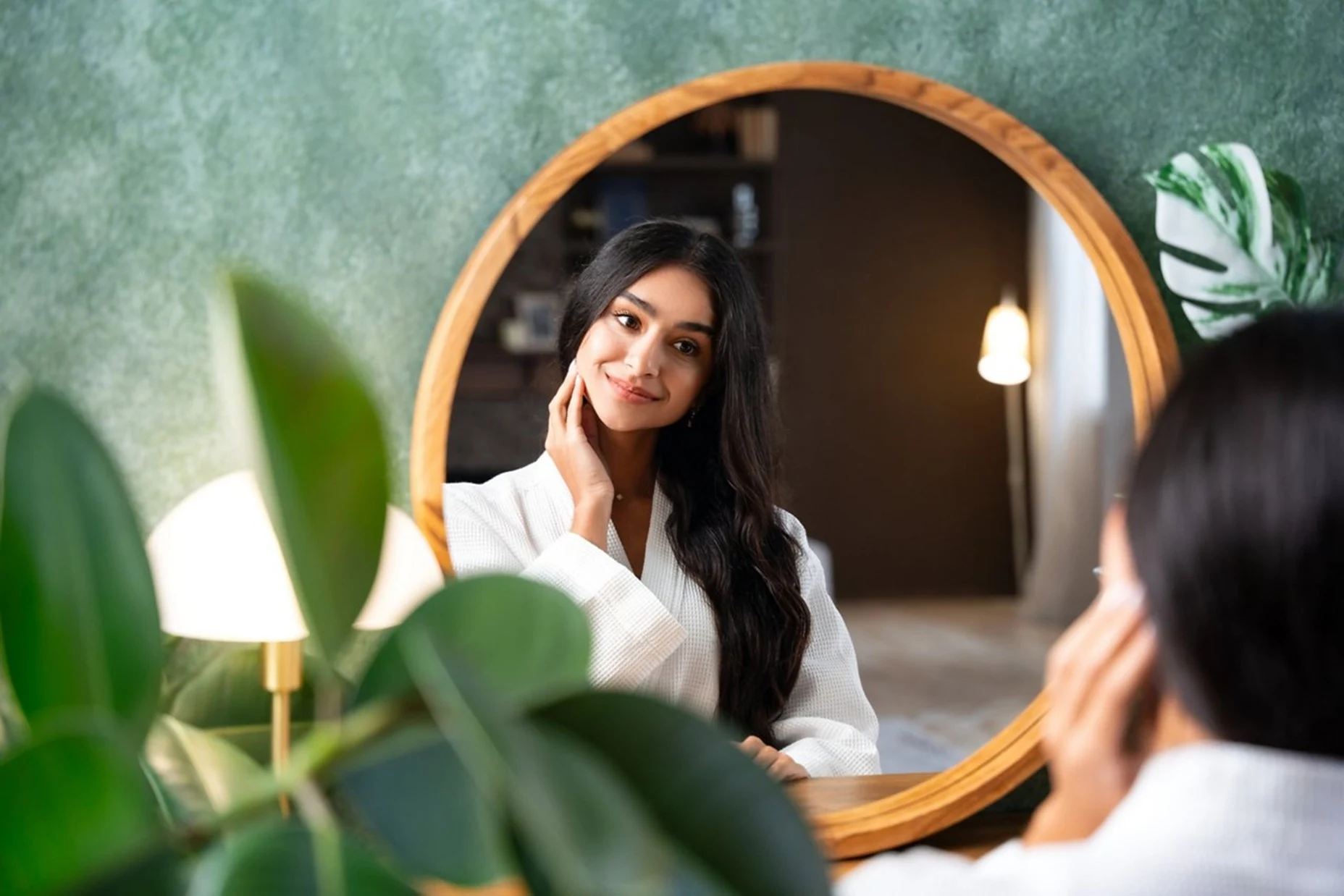 Femeie care se admiră &icirc;n oglindă - frumusețe naturală Foto Herbalife